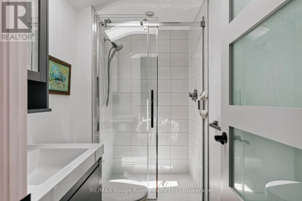 Modern bathroom with glass shower, white tiles, and vanity - 208 Albert Street Cobourg