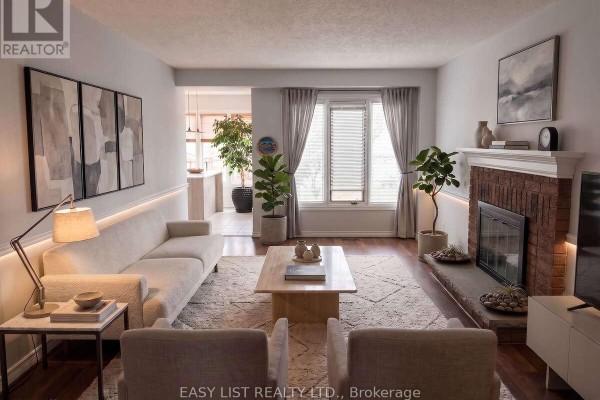 Living room with brick fireplace, large windows, and modern furniture arrangement. - 208 Anastasia Terrace, Mississauga