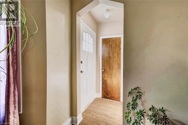 Interior view of the front entrance with a white door and hallway. - 208 Arnold Street, Kitchener