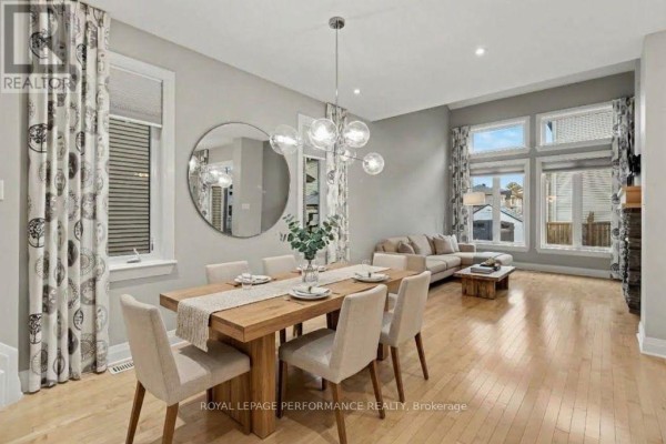 Dining room with a wooden table set for six and a living room with a sofa. - 208 Butterfly Walk, Ottawa