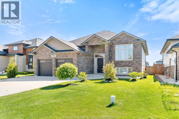 Modern kitchen with stainless steel appliances, dark wood cabinets, and an island with stools. - 208 Clarke, Amherstburg