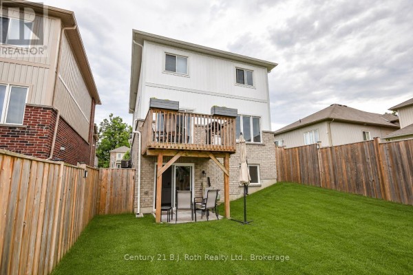 Backyard with a wooden deck, patio furniture, and a wooden fence surrounding the grassy area. - 208 Diana Drive, Orillia