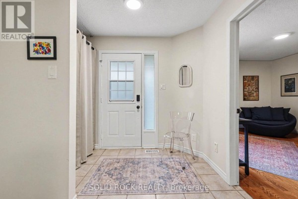 Foyer with tiled floor, white door, and a clear acrylic chair. - 208 Jamieson Street, Mississippi Mills