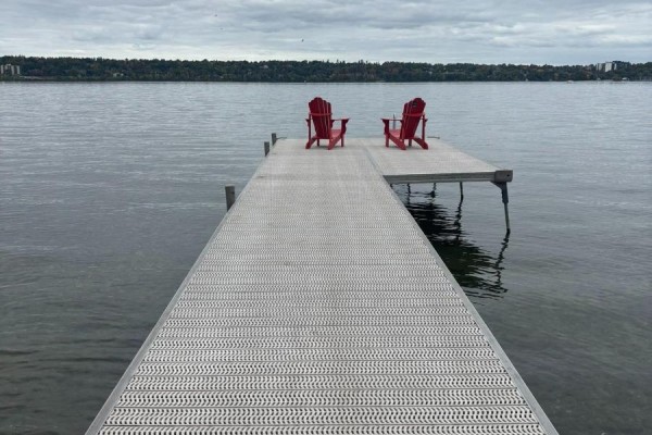 Two red Adirondack chairs sit on the end of a long dock facing the water. - 208 Kempview Lane, Barrie