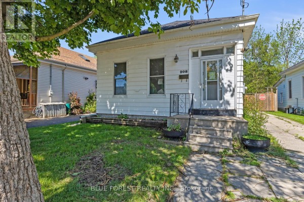 Exterior view of a small white house with a gabled roof and front porch. - 208 Maitland Street, London East
