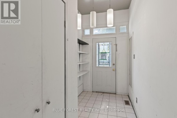 Entranceway with a white door, tiled floor, and white shelving unit. - 208 Maitland Street, London East