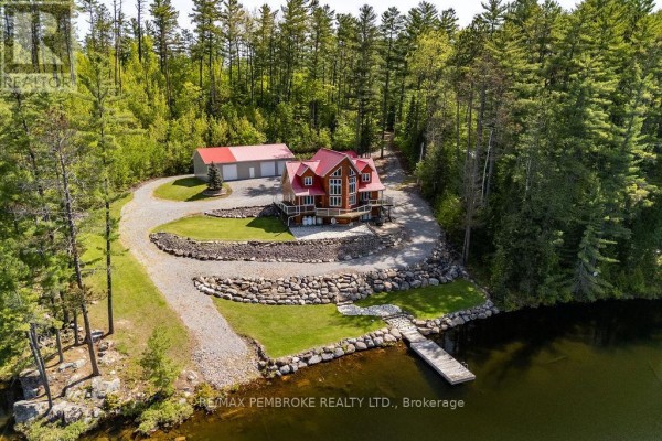 Exterior view of a red-roofed wooden house with a detached garage, set against a backdrop of pine forest. - 208 Red Fox Trail, Head, Clara And Maria