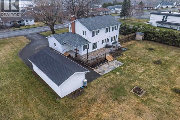 Aerial view of the house, showing the backyard deck, detached garage, and yard. - 208 St Georges Road, Grand Falls