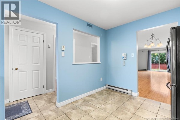 View from kitchen showing beige tile floor, blue walls, and doorway to living area. - 208 Virginia Unit# 116, Dieppe