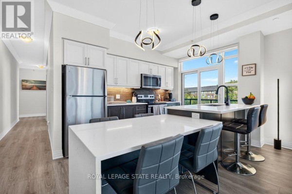 Rooftop terrace with seating areas, concrete benches, and view of building. - 209 - 10 Concord Place, Grimsby