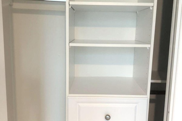 Closet interior with white shelving unit and one drawer, with a hanging rod to the right. - 209 - 18 Yorkville Avenue, Toronto