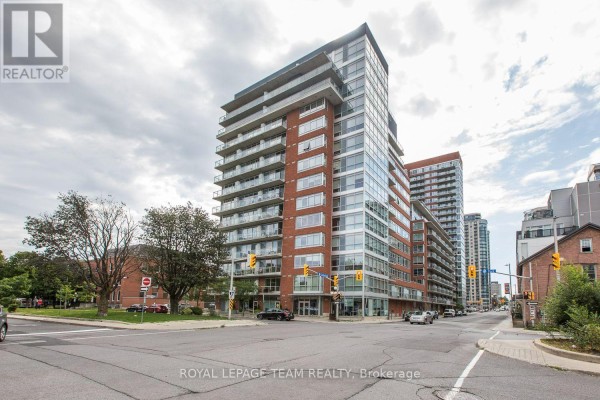 Street view of a multi-story brick and glass apartment building with balconies. - 209 - 180 York Street, Ottawa