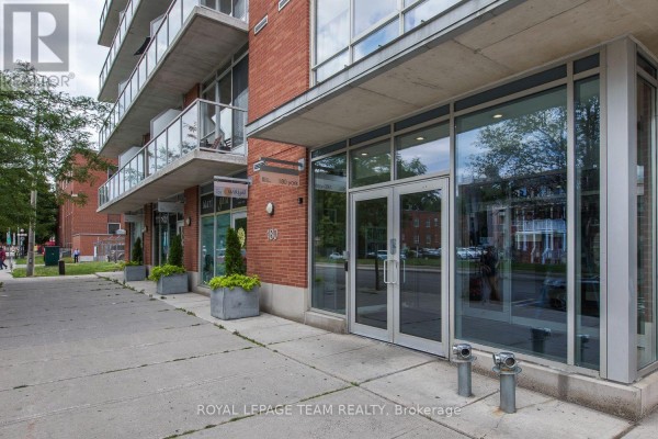 Exterior view of retail storefronts with large glass windows on a brick building. - 209 - 180 York Street, Ottawa