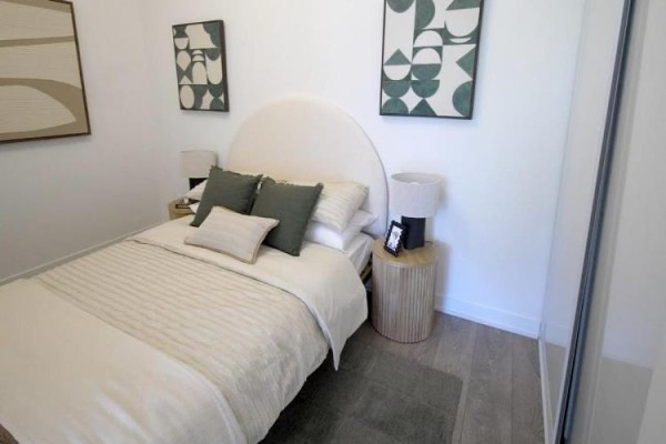 Bedroom with a queen-size bed, green and beige accents, and modern art on a white wall. - 209 - 209 Steels Avenue, Brampton