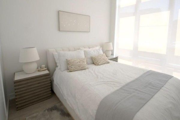 Bedroom with a king-size bed, white bedding, and large windows with sheer blinds on a bright day. - 209 - 209 Steels Avenue, Brampton