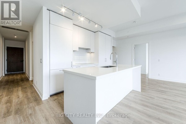 View of the kitchen island and hallway entrance from the living room. - 209 - 36 Brentcliffe Road, Toronto
