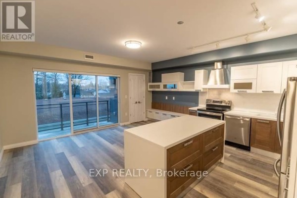 Modern kitchen with white cabinets, stainless steel appliances, and large island. - 6479 Montrose Road, Niagara Falls
