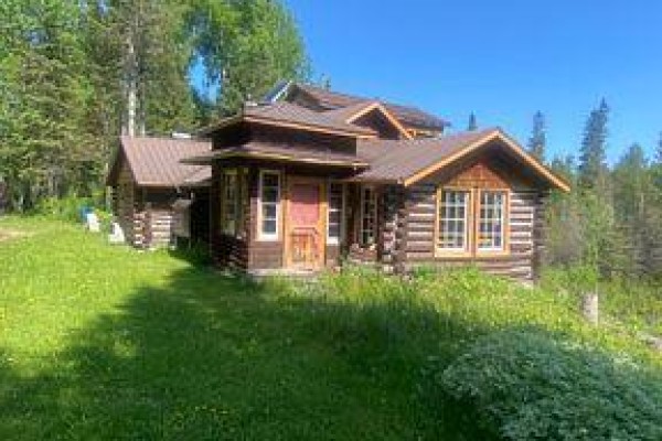 Interior of a garage with wood-paneled walls, workbenches, kitchen appliances, and an ATV. - 209 11 Highway, Fauquier Strickland