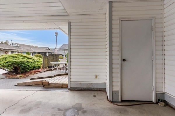 Close-up of a closed white door on the side of the duplex, next to the carport. - 209 7610 Evans Road, Sardis West Vedder, Chilliwack