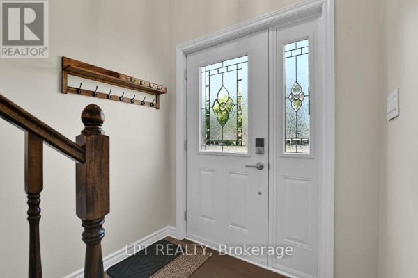 Interior view of the front entrance with a white door and stained glass. - 209 Bridge Street N, North Grenville