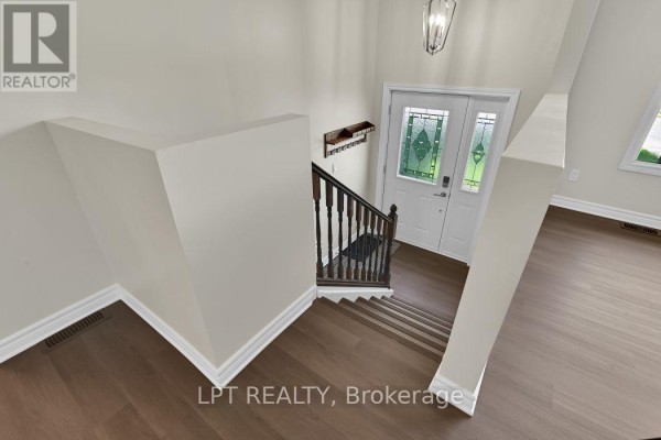 View from the top of the stairs looking down at the entrance and foyer. - 209 Bridge Street N, North Grenville