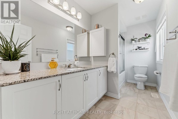 Modern bathroom with double vanity, granite counters, and tub/shower - 209 Quarter Horse Street Ottawa
