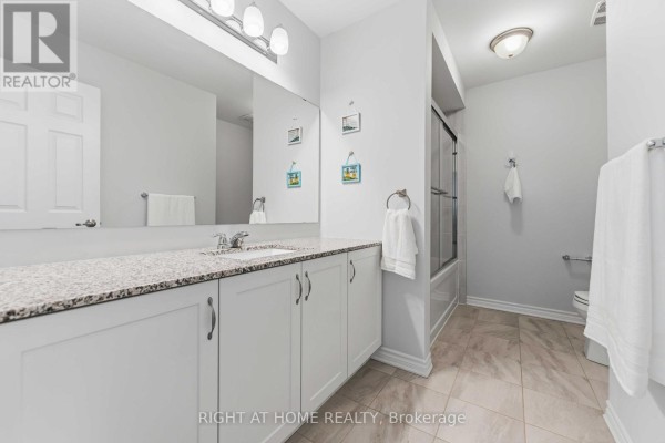 Modern bathroom with double vanity, granite countertop, and shower-tub combo - 209 Quarter Horse Street Ottawa