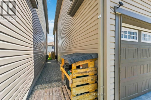 Garage door, trash bin enclosure, and gravel path - 209 Quarter Horse Street Ottawa