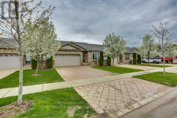 Street view of a townhouse complex with manicured lawns and paved driveways. - 2090 Denview Avenue, London North