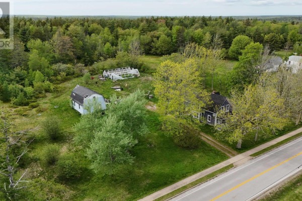 Front view of a two-story dark blue house with white trim, a covered front porch, and shingle siding. - 2091 Highway 203, Kemptville