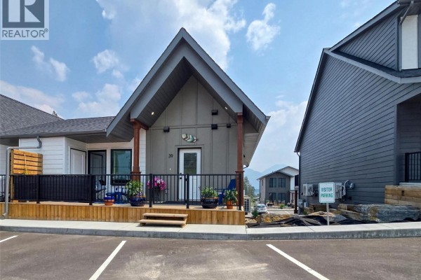Exterior view of townhouse unit 39 with adjacent units and mountain scenery. - 2096 Pine Tree Lane Unit# 39, Invermere
