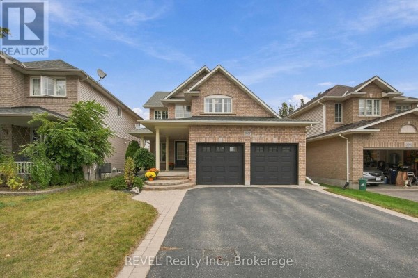 Front exterior of a brick two-story home with a covered porch, entryway, and two car garage. - 2097 Stornoway Street, Oshawa
