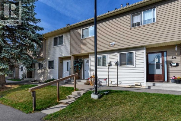Exterior of townhouse units with beige and white siding and stairs. - 21, 2519 38 Street Ne, Calgary