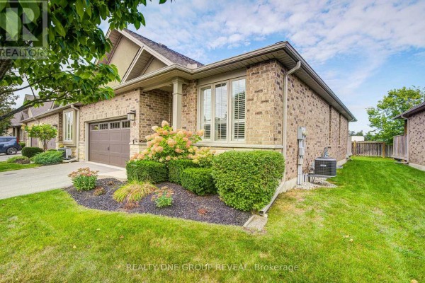 Right side of a brick townhouse showing the side yard, fence, and exterior air conditioning unit. - 21 - 30 Cedar Street, Brant
