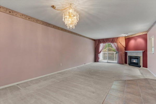Living room with pink walls, a fireplace, and a sliding glass door. - 21 3902 Latimer Street, Abbotsford