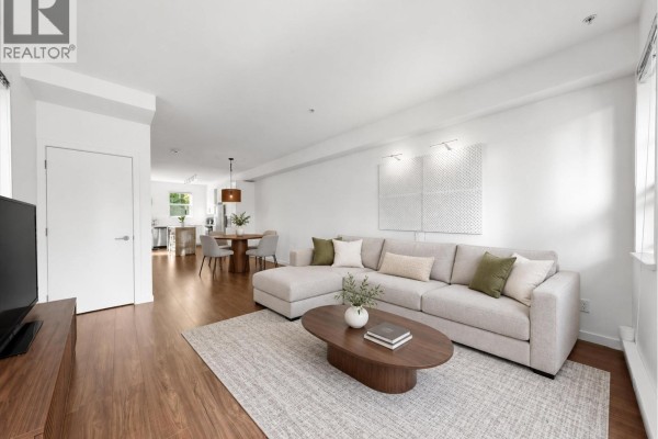 Living room with sectional sofa, coffee table, rug, and view of dining area. - 21 433 Seymour River Place, North Vancouver