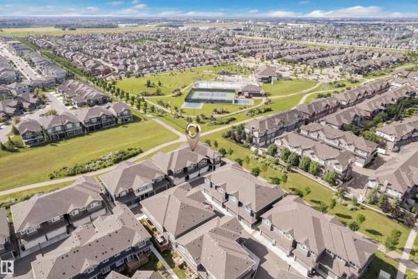 Modern kitchen with white cabinets, stainless steel appliances, and an island. - #21 603 Orchards Bv Sw, Edmonton