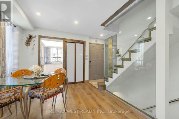 Front entrance of townhouse with steps, snow, and potted plants - 21 Dundonald Street, Toronto
