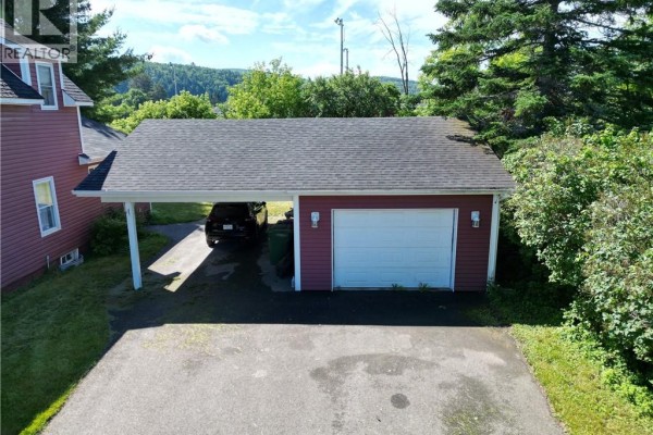 Detached red garage with a white door and an attached single-car carport, seen from above. - 21 Fort Road, Perth Andover
