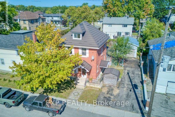 Aerial view of a red brick house with a dark roof and a driveway. - 21 Garrison Street, Ottawa