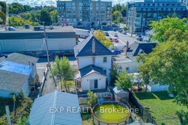 Aerial view of the rear of a house with a backyard, pool, and surrounding buildings. - 21 Garrison Street, Ottawa
