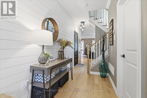 Interior entryway with white shiplap walls, hardwood floors, and a staircase. - 21 Gord Matthews Way, Uxbridge