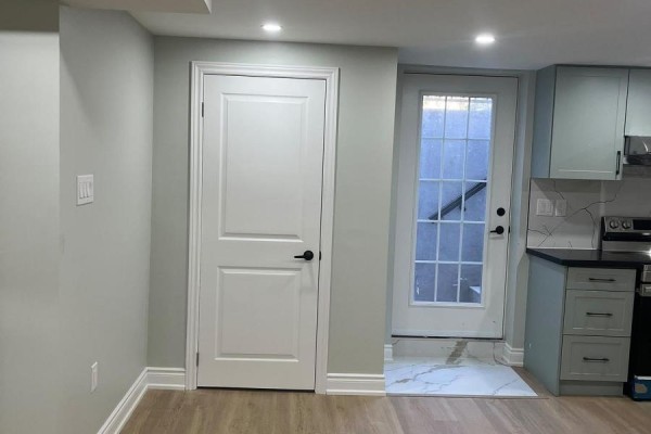Interior view of a room with a white door and a glass-paned door leading outside to stairs. - 21 Hartford Trail, Brampton