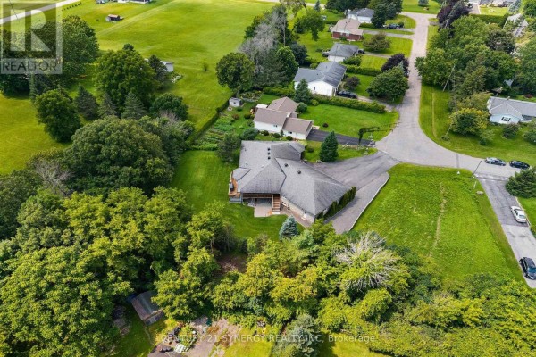Aerial view of a large ranch house surrounded by trees and green lawns. - 21 Holly Drive, Edwardsburgh/cardinal