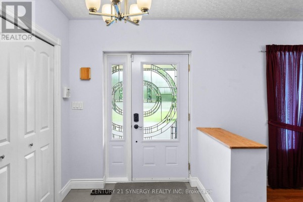 Interior view of a bright foyer with a glass-paneled front door and white double closet. - 21 Holly Drive, Edwardsburgh/cardinal