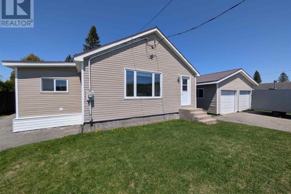 Empty room with wood-paneled walls, brown carpet, and two closets. - 21 Joliet St, Wawa