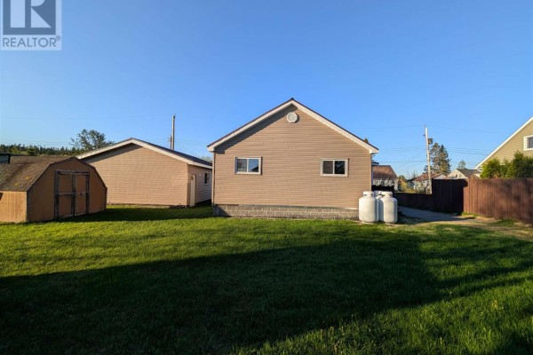 Living and dining area with wood floors, large windows, and a ceiling fan. - 21 Joliet St, Wawa