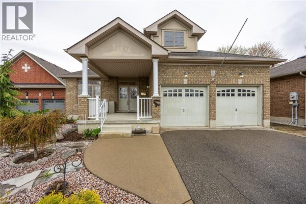 Foyer area with double glass doors, tiled floor, and a dining room with a wooden table and chairs. - 21 Kelly Drive, Port Dover