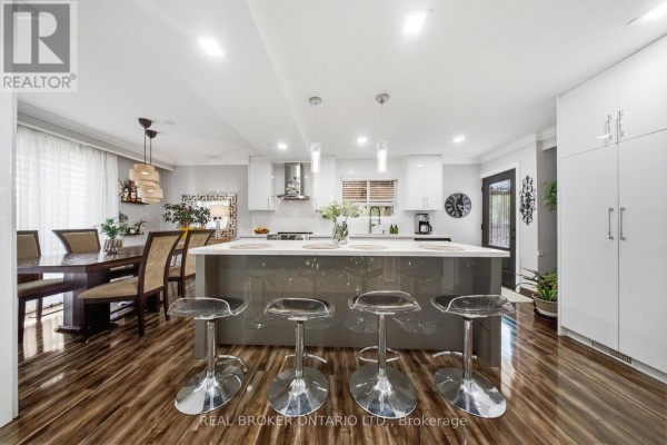 Open concept kitchen and dining area with island, bar stools, and modern cabinetry. - 21 Kendleton Drive, Toronto
