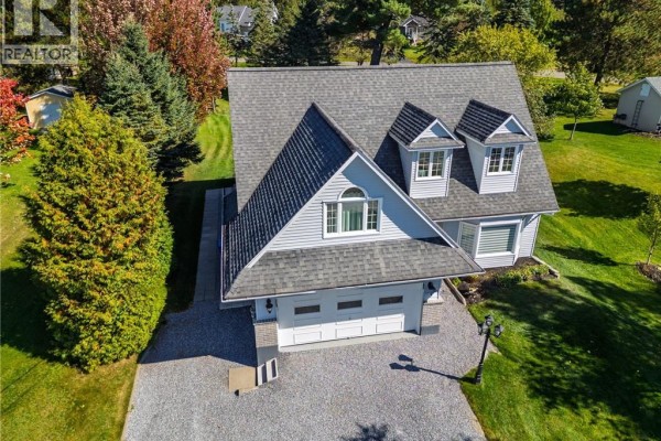 Aerial view of the front of a two-story grey house with a double garage and dormer windows. - 21 Principale Street, Riviere Verte